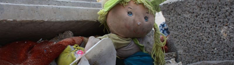 Bilde av dokke i utbombet ruin